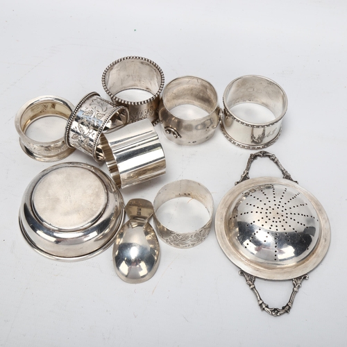 1444 - A group of various silver napkin rings, a George III silver caddy spoon, and a plated tea strainer o... 