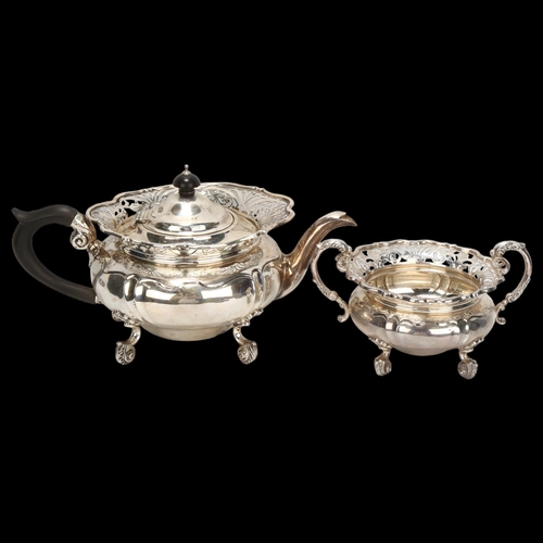 1468 - A Victorian silver teapot and matching sugar bowl, pierced fretwork surrounds on cast scrolled feet,... 