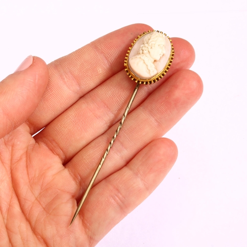 1127 - A Victorian pink coral cameo stickpin, circa 1860, relief carved depicting male profile, in unmarked... 