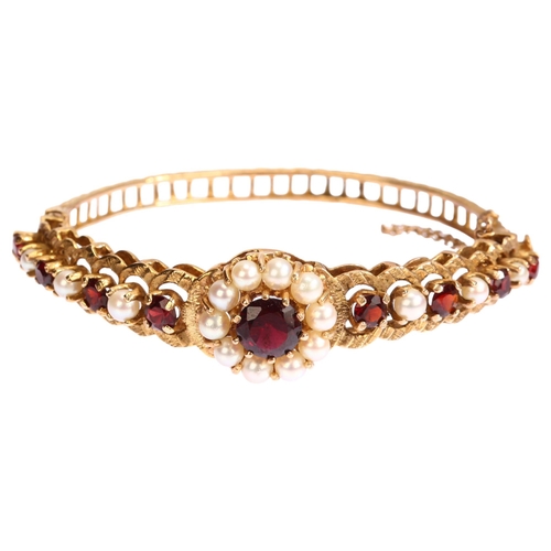 1131 - A mid-20th century 9ct gold garnet and pearl cluster hinge bangle, with central flowerhead cluster f... 