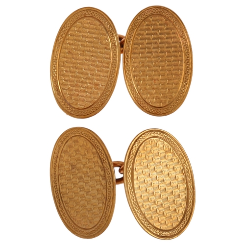 1194 - A pair of Art Deco 9ct gold oval cufflinks, with engine turned decoration, London 1927, length 18.2m... 