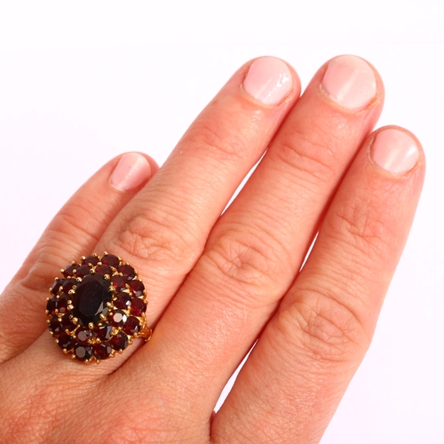 1195 - A Continental 18ct gold garnet oval cluster ring, set with oval mixed and round-cut garnets, setting... 