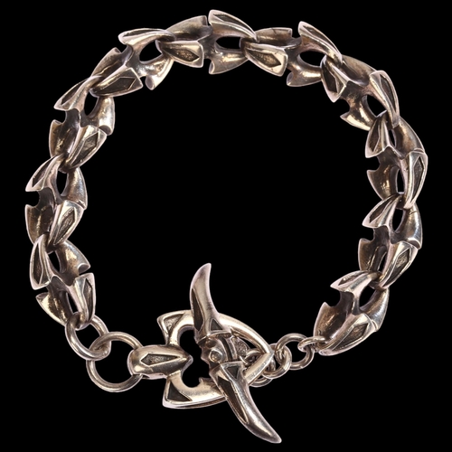 1293 - A sterling silver vertebrae link bracelet, with bow and arrowhead interlocking clasp, length 23.5cm,... 