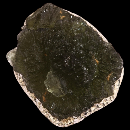 1299 - A moldavite natural green glass and silver ring, setting height 25mm, size N, 16.6g.  Moldavite is a... 