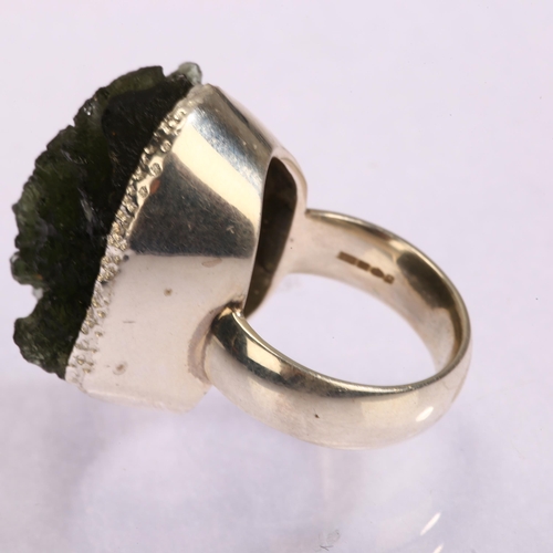 1299 - A moldavite natural green glass and silver ring, setting height 25mm, size N, 16.6g.  Moldavite is a... 