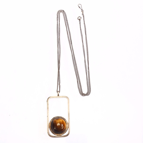 1306 - A Scottish modernist silver and cabochon tigers eye set abstract pendant on silver chain, marked KND... 