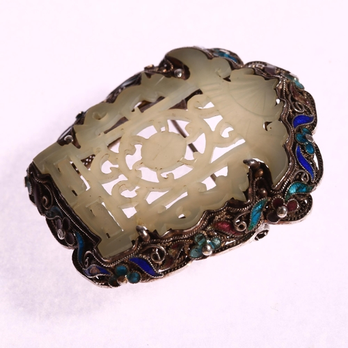 1340 - A Chinese carved and pierced jade brooch in silver filigree and enamel shaped setting, 50 x 45mm, 19... 