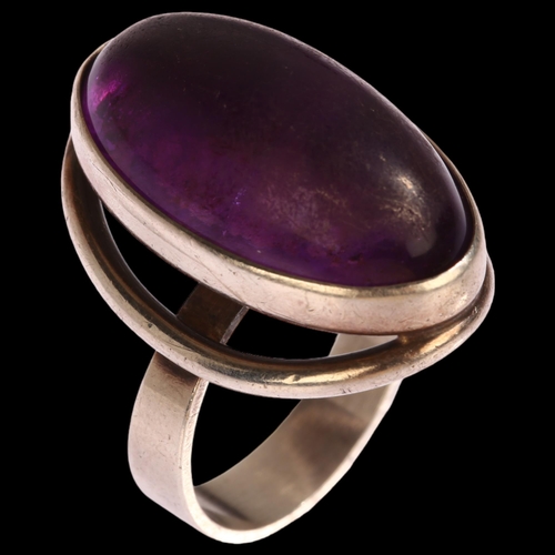 1348 - N E FROM - a Danish sterling silver ring set with a large oval cabochon amethyst, setting height 25m... 