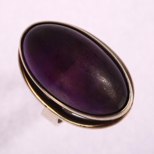 1348 - N E FROM - a Danish sterling silver ring set with a large oval cabochon amethyst, setting height 25m... 