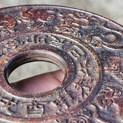 150 - A Chinese relief cast-bronze mirror, diameter 17.5cm, and a Chinese relief carved stone bi-disc, dia... 