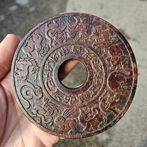 150 - A Chinese relief cast-bronze mirror, diameter 17.5cm, and a Chinese relief carved stone bi-disc, dia... 