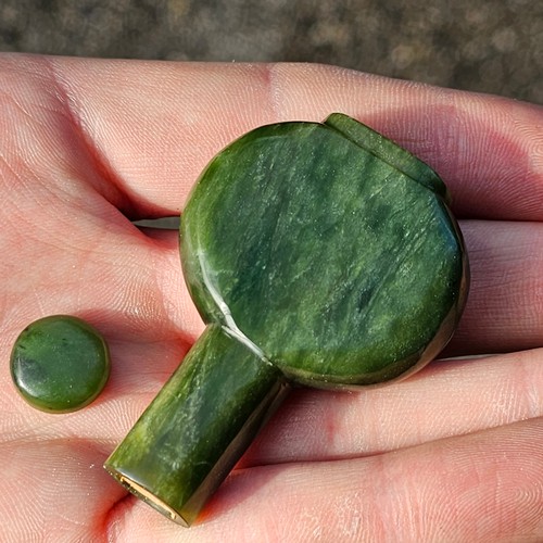 135 - A Chinese spinach jade snuff bottle and stopper, on carved white jade stand, height 8cm