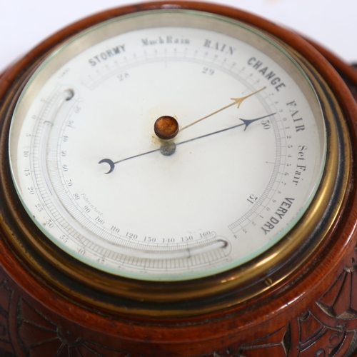 105 - An Edwardian carved oak-cased combination aneroid barometer with thermometer, diameter 20cm