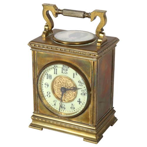 115 - A large brass-cased carriage clock, with a circular paper portrait panel to the top, and swing handl... 