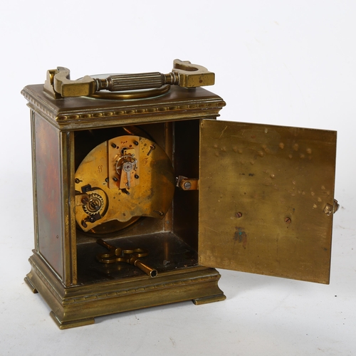 115 - A large brass-cased carriage clock, with a circular paper portrait panel to the top, and swing handl... 