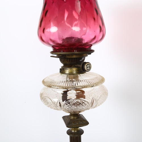 20 - A brass Corinthian column oil lamp, with a frilled cranberry glass shade, H77cm