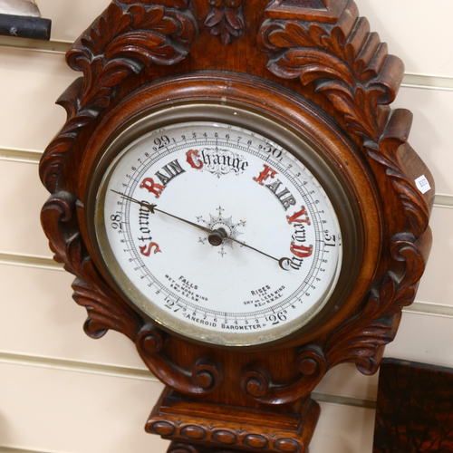 303 - A lovely carved oak aneroid barometer, with mercury thermometer, length 95cm