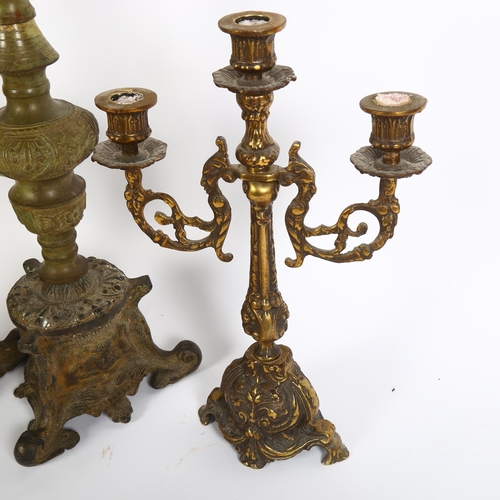 318 - A pair of Continental style brass floor standing candle holders, with embossed decoration and ornate... 