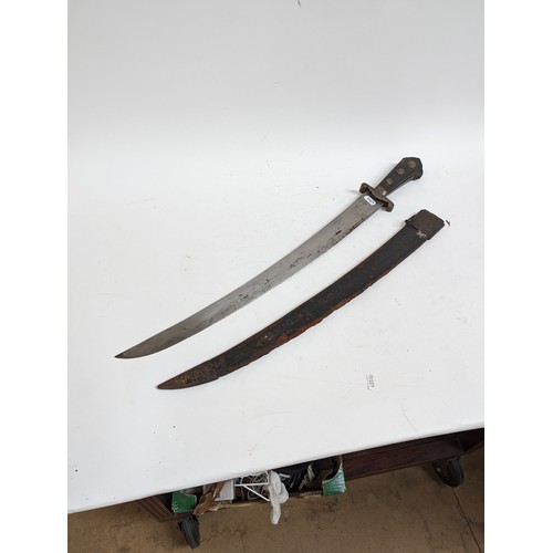 56 - An Indo-Persian short curved sword with steel guard and carved wood handle, together with leather sc... 