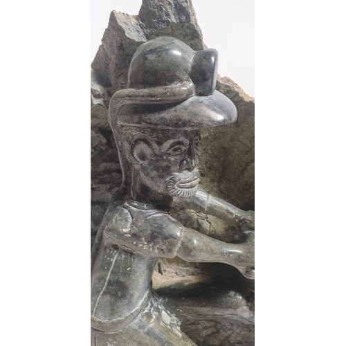 11 - A hand carved green serpentine sculpture, depicting a miner, H46cm (AF)