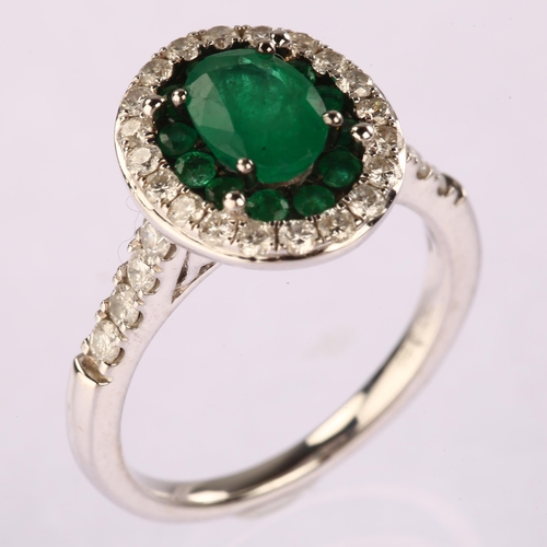 1112 - A modern 18ct white gold emerald and diamond oval cluster ring, set with oval and round-cut emeralds... 