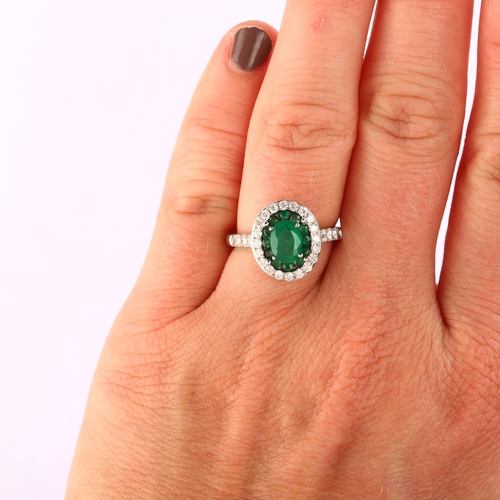 1112 - A modern 18ct white gold emerald and diamond oval cluster ring, set with oval and round-cut emeralds... 