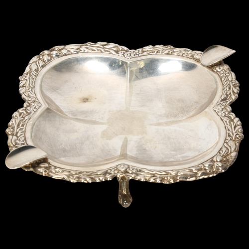 1561 - A Continental sterling silver ashtray, lobed form with relief embossed floral rim, on 4 feet, width ... 