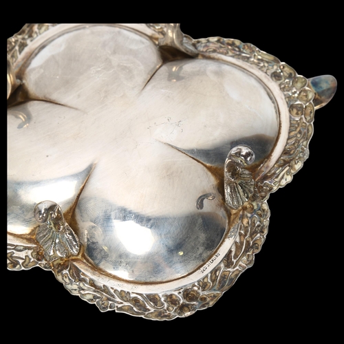 1561 - A Continental sterling silver ashtray, lobed form with relief embossed floral rim, on 4 feet, width ... 