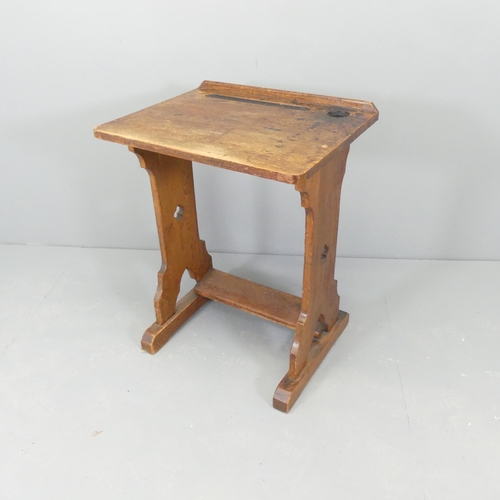 2707 - A Gothic oak topped school desk / writing table on pine base, with cut-out decoration. 56x74x45cm.