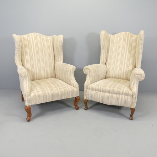 2582 - An early 20th century his and hers pair of walnut and upholstered wingback fireside armchairs.