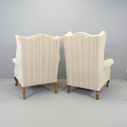 2582 - An early 20th century his and hers pair of walnut and upholstered wingback fireside armchairs.