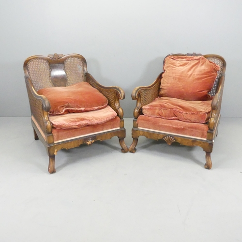 2592 - A pair of Georgian walnut bergere arm chairs with cane panels. A/F.