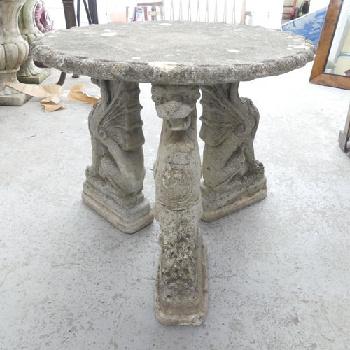 2626 - A weathered concrete low circular garden table on dragon supports. 58x51cm.