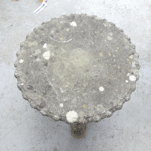 2626 - A weathered concrete low circular garden table on dragon supports. 58x51cm.