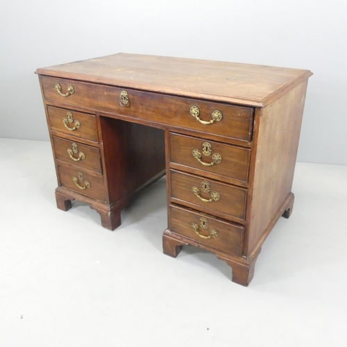 2640 - A Georgian oak center standing kneehole writing desk, with well-fitted top drawer and six drawers un... 