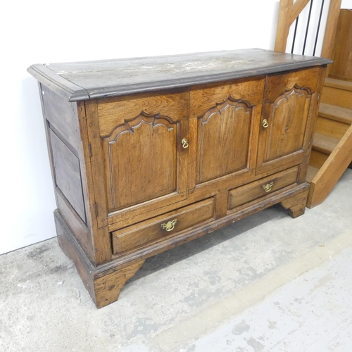 2645 - An antique panelled oak mule chest, with two cupboard doors and drawers under, and raised on bracket... 