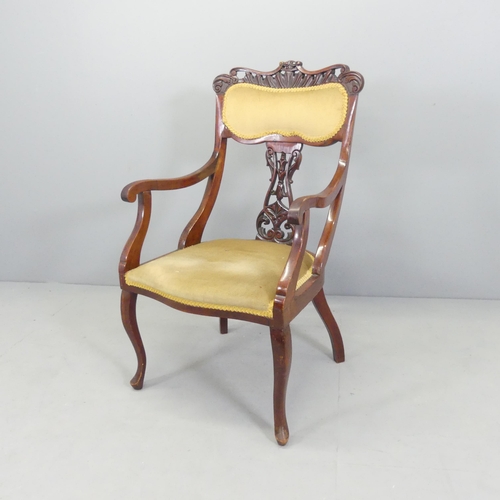 2710 - An Edwardian mahogany and upholstered desk chair with carved and pierced decoration.