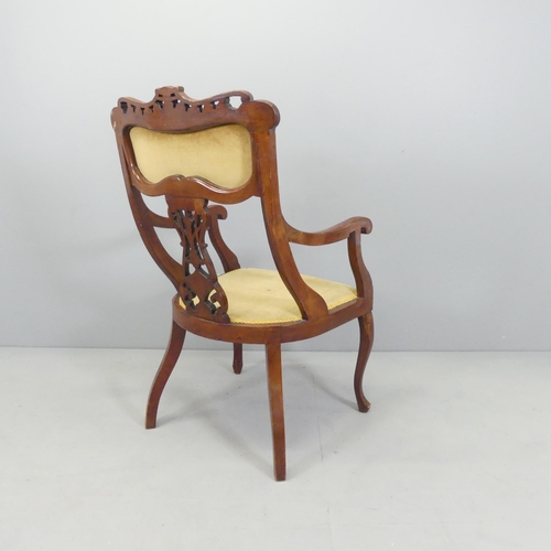 2710 - An Edwardian mahogany and upholstered desk chair with carved and pierced decoration.