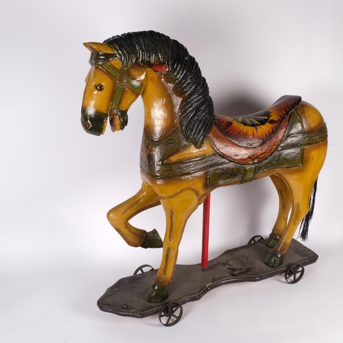 535 - A late 19th/early 20th century German hand-painted child's play-horse on wheeled stand, H77cm