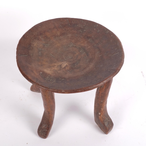 709 - An Antique African carved hardwood stool, with shallowed seat, diameter 24cm, height 22cm