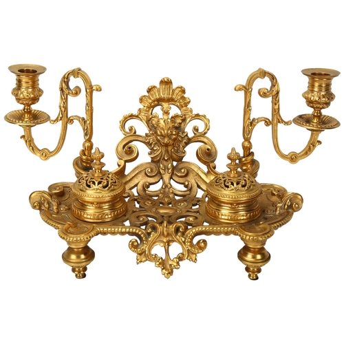 127 - A gilt-bronze Rococo style desk stand, late 19th century, with acanthus candle brackets, and lidded ... 