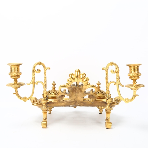 127 - A gilt-bronze Rococo style desk stand, late 19th century, with acanthus candle brackets, and lidded ... 