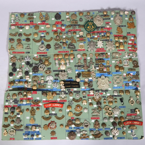 132 - A large collection of military cap badges, buttons, cloth badges and insignia mounted on 18 cards pl... 