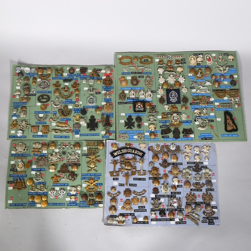 132 - A large collection of military cap badges, buttons, cloth badges and insignia mounted on 18 cards pl... 