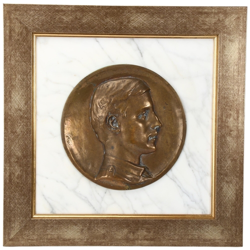 135 - A bronze relief plaque depicting Wilfred Owen (1893 - 1918), set into white marble background in mod... 