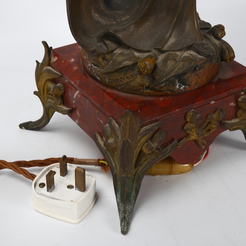 137 - An Art Nouveau oil lamp, supported by a bronze patinated spelter figure of a woman, lustre glass ves... 