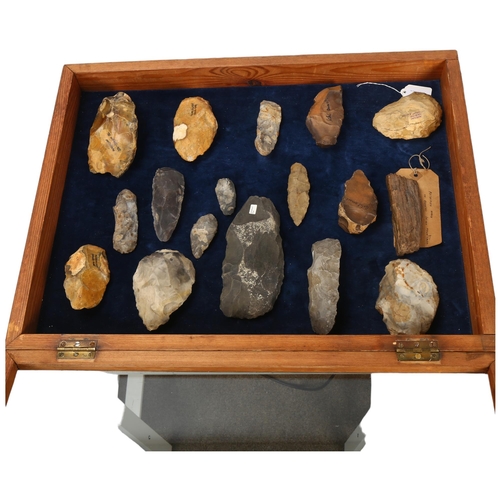 139 - A museum display of flint hand axes, spearheads, petrified wood specimen etc, in glazed pine display... 