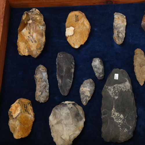 139 - A museum display of flint hand axes, spearheads, petrified wood specimen etc, in glazed pine display... 