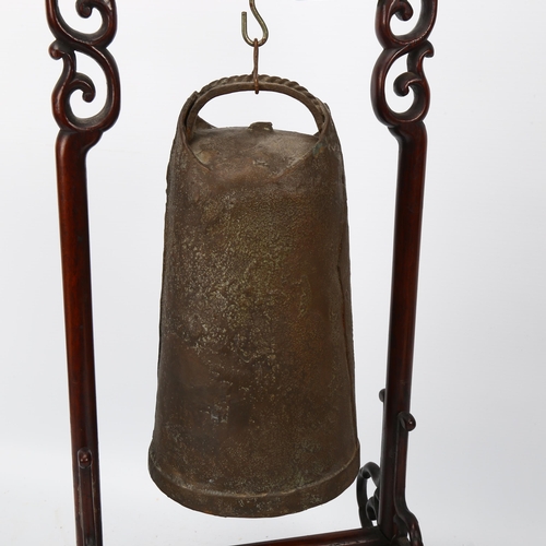 245 - A Chinese bronze bell on carved and pierced hardwood stand, height 46cm