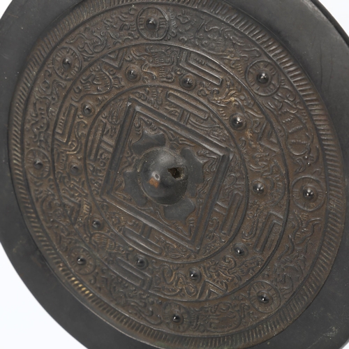 256 - A Chinese relief cast bronze mirror, diameter 19cm, on modern metal stand